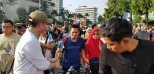 Foto/Ket:Salah Satu Pengurus Relawan DJM 1 Kali Lagi DKI Jakara Kosuman terlihat sedang membagikan Bunga Mawar dan sambil menyebutkan "Indonesia Rumah Kita Bersama"