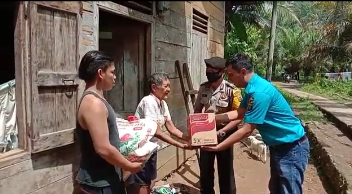 Kanit Reskrim Polsek Sibabangun, Aipda Khairul Ikhsan, bersama Bripka Agus Priadi saat menyerahkan paket sembako kepada warga terdampak Covid-19 di Lingkungan IX Sikkam Kelurahan Sibabangun, Kecamatan Sibabangun, Kabupaten Tapanuli Tengah